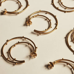 Candongas grandes de media luna con bolitas soldadas vista cercana