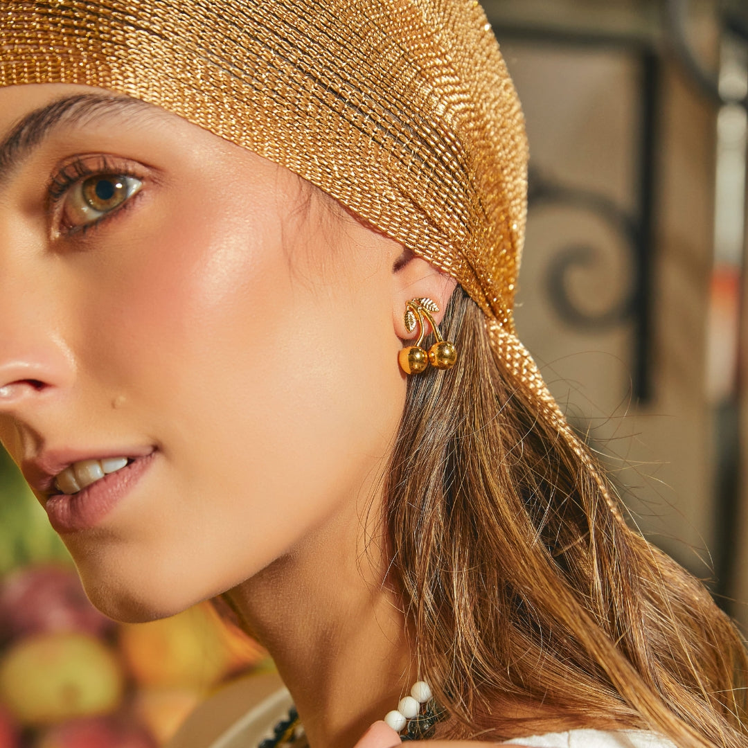 Aretes tipo topo de cereza dorados en modelo