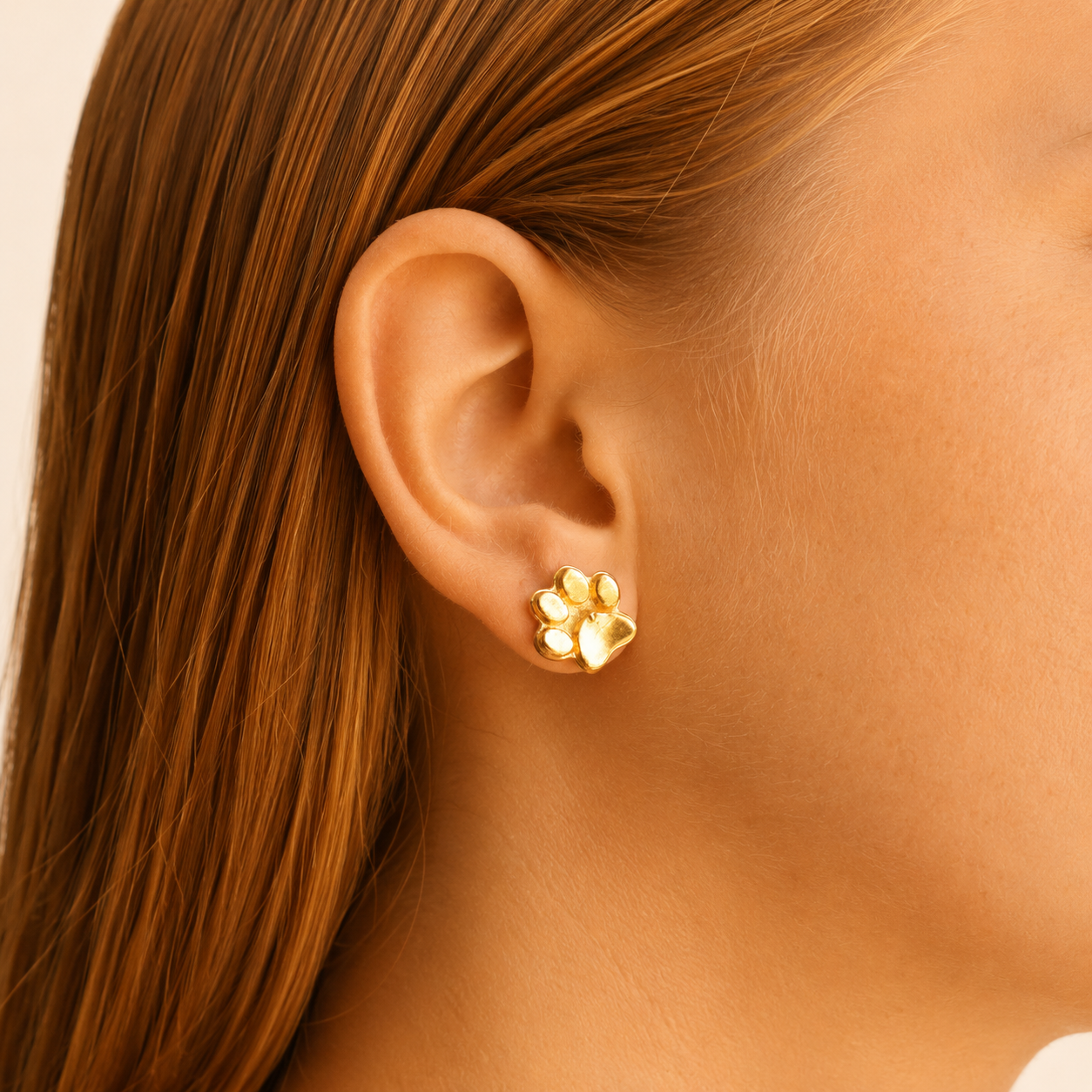 Detalle de aretes con huella de perro en oreja de persona  Brezo Jewelry