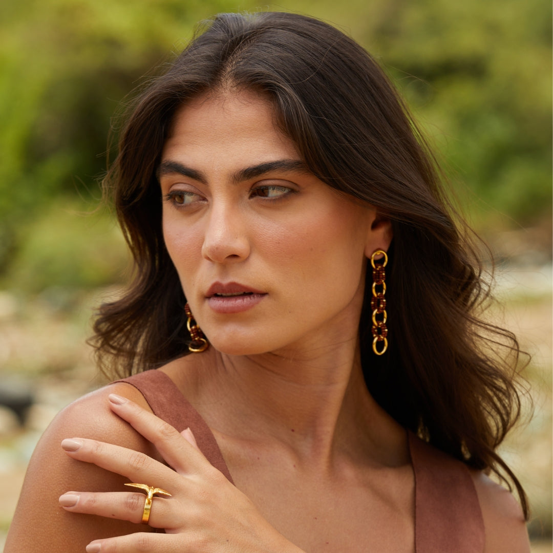 Aretes largos entrelazados tejidos con marrón y dorado en modelo