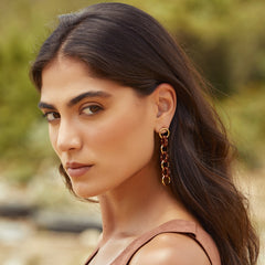 Aretes largos entrelazados tejidos con marrón y dorado en modelo
