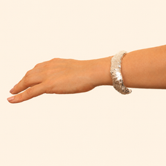 Detalle de brazalete plateado con textura de fresa en persona